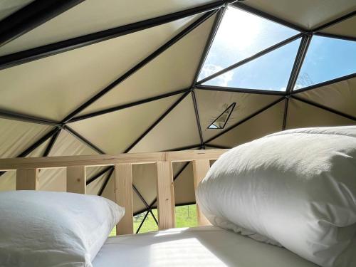 邦尼克的住宿－Camping de Vliert，一张位于带大窗户的帐篷内的床铺