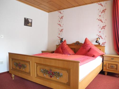 Schlafzimmer mit einem Holzbett mit roten Kissen in der Unterkunft Haus am Stryckweg in Willingen