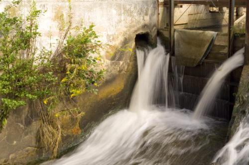 a waterfall in a dam with water coming out of it at Frühstückspension Kleinschuster in Burgau