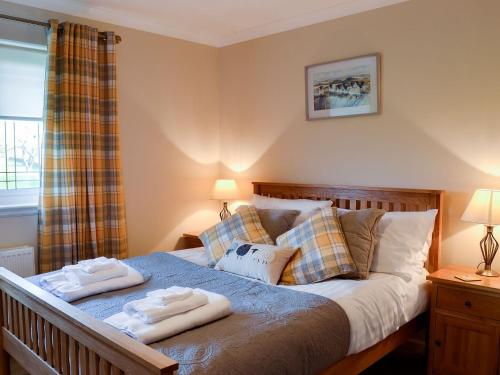 a bedroom with a bed with two towels on it at Hillview in Beith