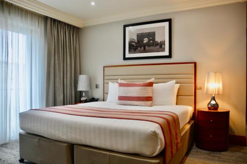 a bedroom with a bed and a large window at Sanctum Maida Vale in London