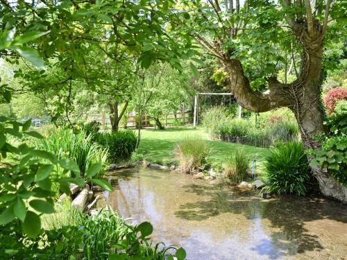 a garden with a pond and trees and grass at Bannsvale Summer House - W43195 in St. Agnes