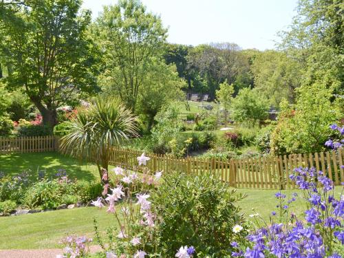a garden with flowers and a wooden fence at Bannsvale Summer House - W43195 in St. Agnes