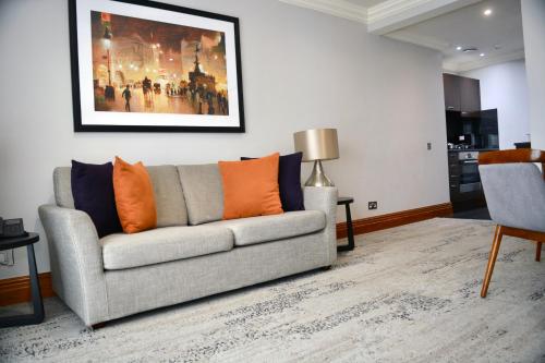 a living room with a couch and a painting on the wall at Sanctum Maida Vale in London