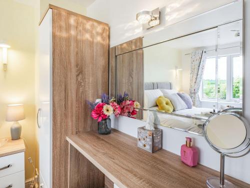 a bathroom with a mirror and a bed in a room at Comfy Kozy Cottage in Louth