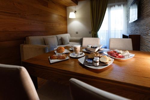 a table with plates of food on top of it at Sottovento Luxury Hospitality in Bormio