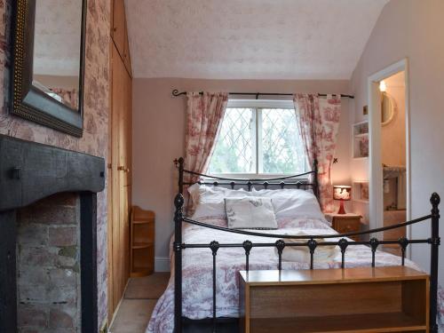 a bedroom with a bed and a window at Rebeccas Cottage in Ashby Saint Ledgers