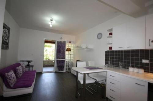 een keuken met een tafel en een bank in een kamer bij Apartment Poropat in Poreč