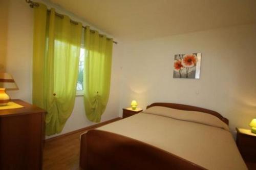 a bedroom with lime green curtains and a bed at Apartment Poropat in Poreč