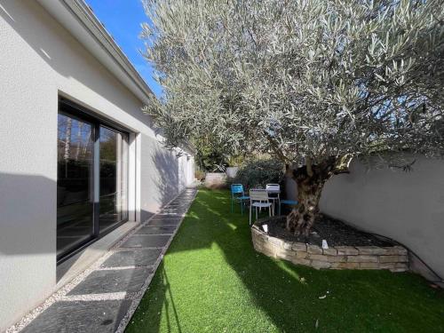 a tree in a yard next to a house at Chill & Work - Villa spa & piscine à Toulouse in Toulouse