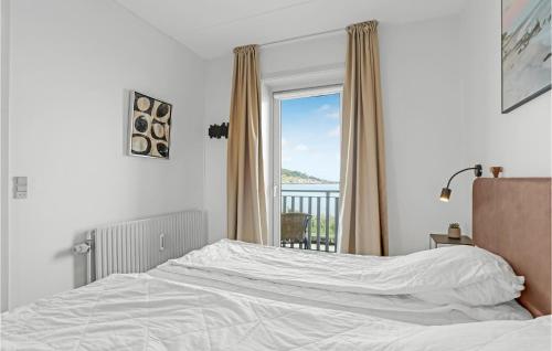 een slaapkamer met een wit bed en een raam bij Nice Apartment In Allinge With Wifi in Allinge