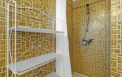 a shower in a bathroom with a brick wall at Nice Apartment In Allinge With Wifi in Allinge