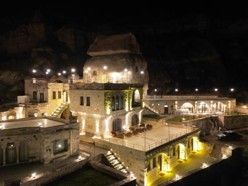 un edificio con luces encendidas por la noche en Secret Hill Cave Suites, en Göreme