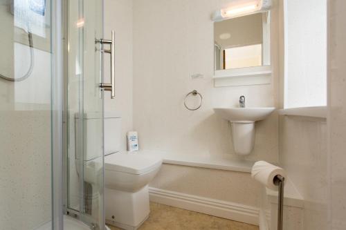 a bathroom with a toilet and a sink and a shower at The Glendeveor in Newquay