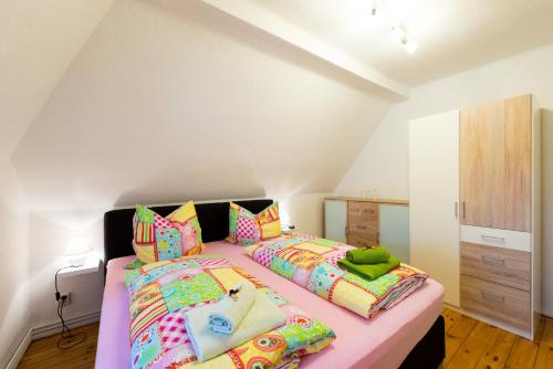 クヴェードリンブルクにあるHarztour 2 Ferienwohnungのベッドルーム1室(カラフルな枕付きのベッド2台付)