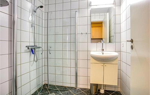 uma casa de banho com um lavatório e um chuveiro em Lovely Apartment In Nex With Sauna em Neksø