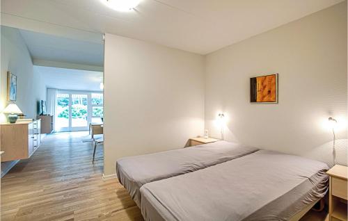 NeksøにあるBeautiful Apartment In Nex With Sauna, Wifi And Outdoor Swimming Poolのベッドとダイニングルームが備わるホテルルームです。