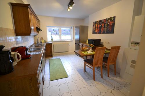 a kitchen with a table and two chairs and a kitchen with a sink at Zauber der Pfalz in Römerberg