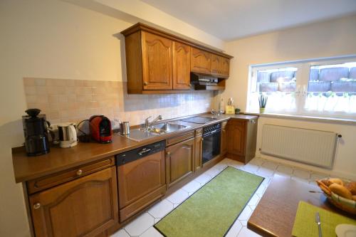 a kitchen with wooden cabinets and a sink and a window at Zauber der Pfalz in Römerberg