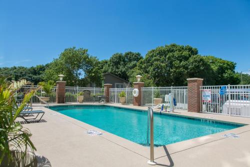a swimming pool with a white fence around it at Holiday Inn Winter Haven by IHG in Winter Haven