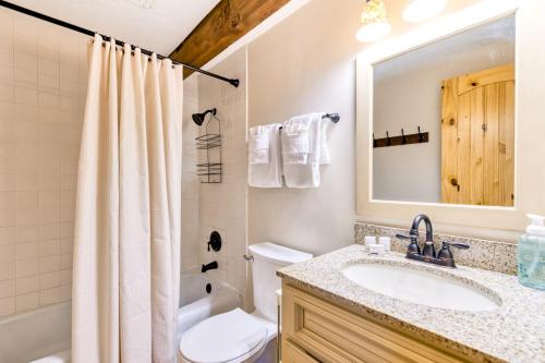 een badkamer met een wastafel, een toilet en een spiegel bij Briarcliff A-03 in Sugar Mountain
