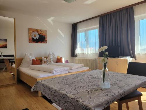 ein Hotelzimmer mit einem Bett und einem Tisch mit einer Vase darauf in der Unterkunft Ferienhaus Panorama in Mutters