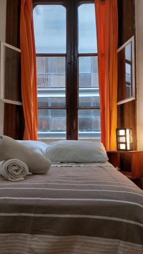 Cama en habitación con ventana grande en 06 Central Hostel Buenos Aires en Buenos Aires