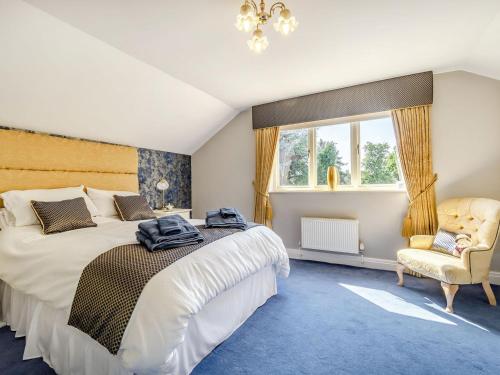 a bedroom with a bed and a chair and a window at The Hawthorns in Ottringham