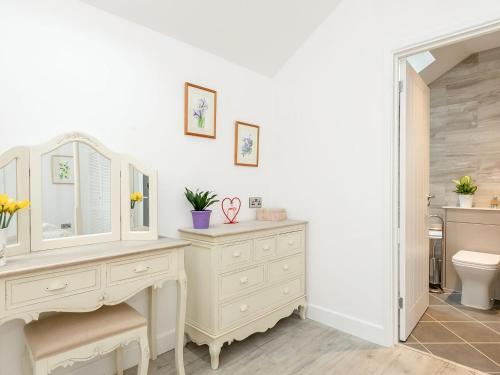 a bathroom with a white vanity and a toilet at Bay Cottage in Wereham