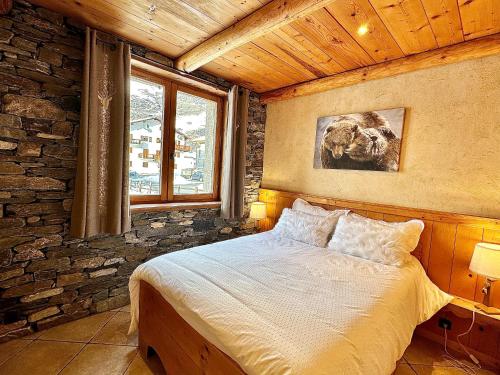 a bedroom with a bed and a stone wall at Chalet Les Cocales Résidence Séjour et Nuitées B&B - Appartement Pin Sylvestre in Bessans
