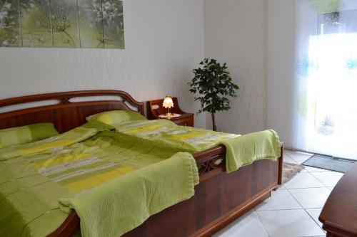 a bedroom with a bed with a green comforter at Zauber der Pfalz in Römerberg