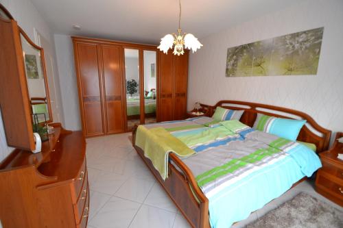 a bedroom with a bed and a dresser and a chandelier at Zauber der Pfalz in Römerberg