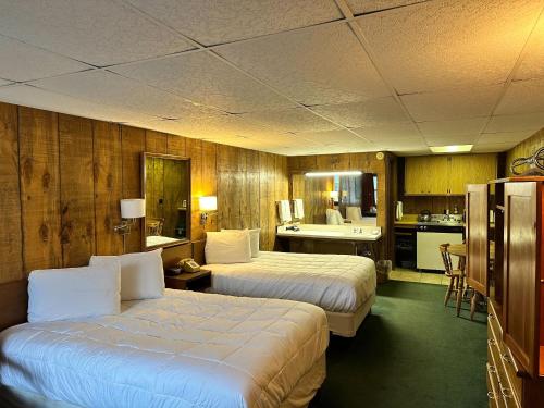 a hotel room with two beds and a kitchen at Maple Leaf Inn Lake Placid in Lake Placid