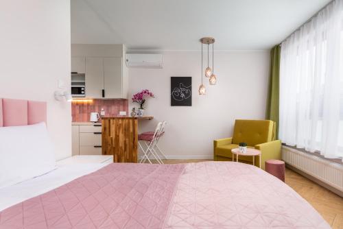 1 dormitorio con cama rosa y cocina en Old Town Szczecin Pink, en Szczecin