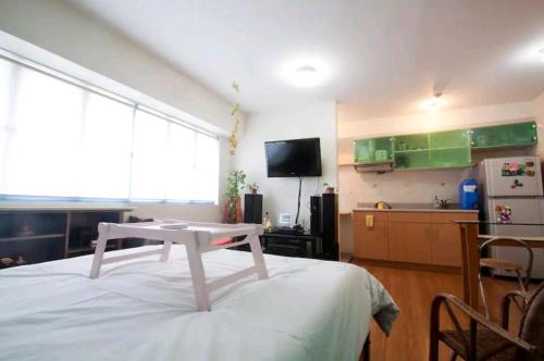 マニラにあるWestParc Cedar Alabangの白いベッド1台(テーブル付)が備わる客室です。