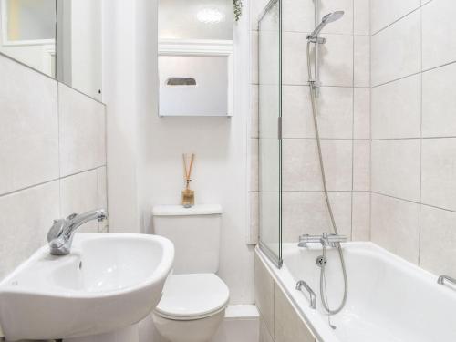 a bathroom with a sink and a toilet and a shower at Thornton Cottage in Grizebeck