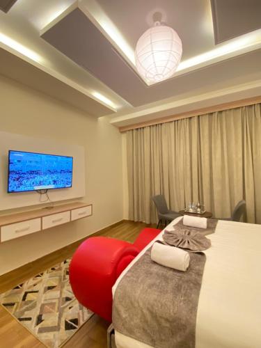 um quarto com uma cama grande e uma televisão na parede em فندق جولدن توليب أبها - GOLDEN TULIP ABHA HOTEl em Abha