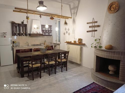 cocina y comedor con mesa y chimenea en Casa Tesoro, en Cisternino