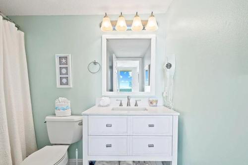 uma casa de banho com um lavatório branco e um espelho. em Beachfront Retreat- "The Getaway" em Destin
