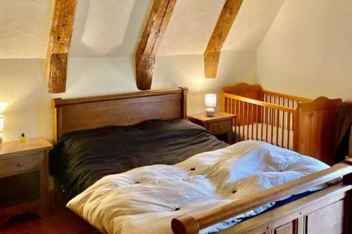 1 dormitorio con 1 cama grande y cabecero de madera en Le Gite des Montagnes - Saint Projet de Salers, en Saint-Projet-de-Salers
