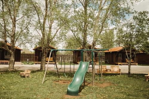 a playground with a green slide in a park at Teton Valley Resort in Victor