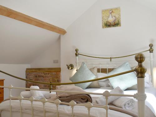 a bedroom with a bed with white sheets and pillows at The Hay Barn - Ukc4135 in Arlingham