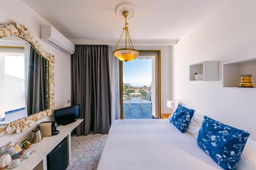 una camera d'albergo con letto e specchio di HOTEL ZI'NTONIO a Scala