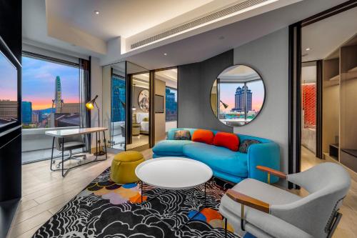 a living room with a blue couch and a table at Hotel Indigo Taipei North by IHG in Taipei