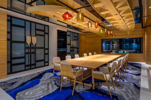 a conference room with a large wooden table and chairs at Hotel Indigo Taipei North by IHG in Taipei