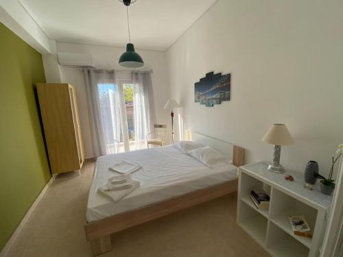 a bedroom with a white bed and a window at Nefeli Β1 apartment in Thiva