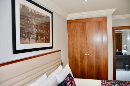 a bedroom with a bed with a picture on the wall at Sanctum Maida Vale in London
