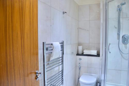 a bathroom with a toilet and a glass shower at Sanctum Maida Vale in London