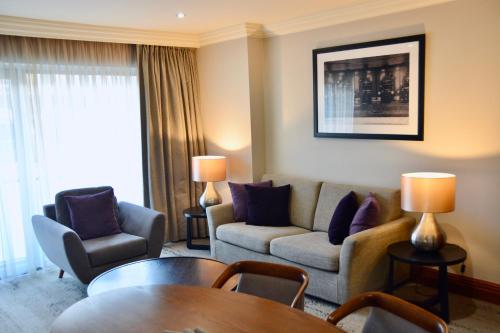 a living room with a couch and chairs and a table at Sanctum Maida Vale in London