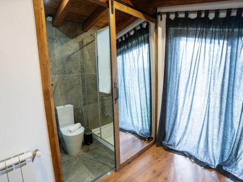a bathroom with a toilet and a glass door at Quinta Lourena - Casa do Desassossego in Covilhã